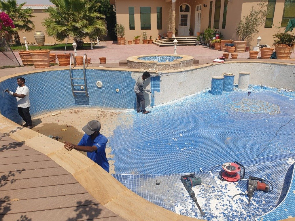 Pool maintenance team working on a tiled swimming pool